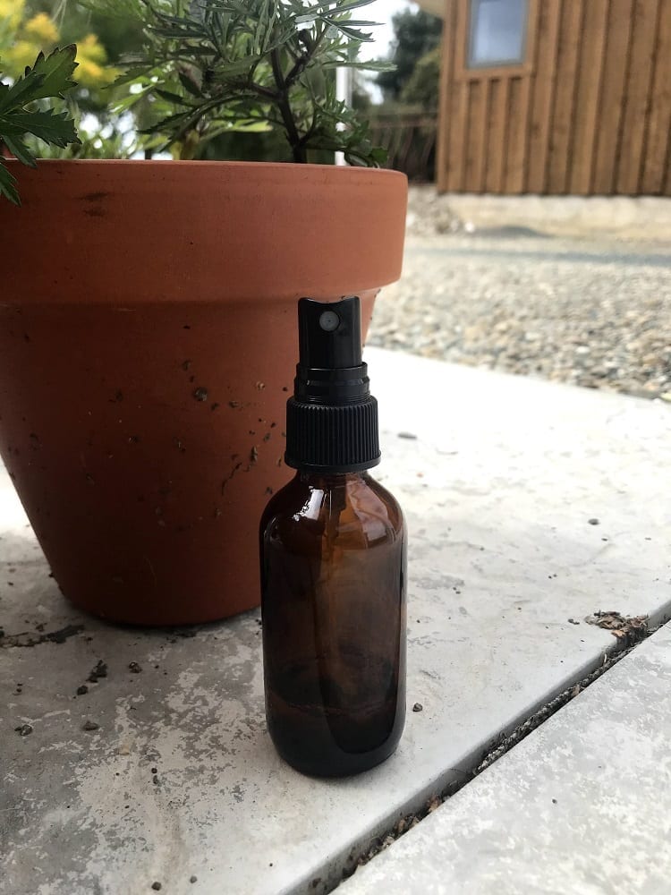 small spray bottle next to a terracotta pot