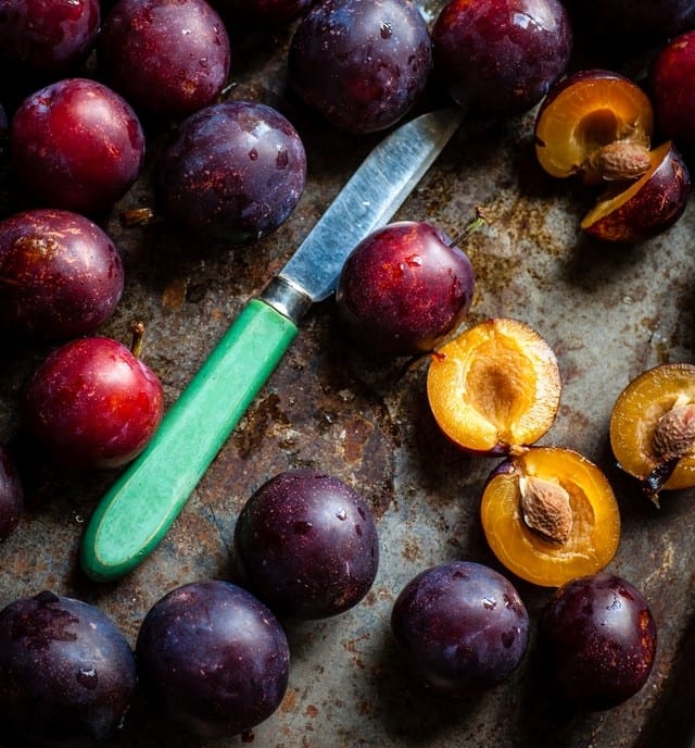 plum and plum pit and knife